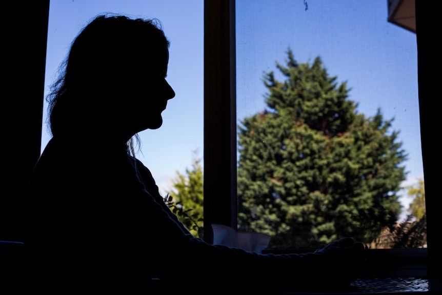 Silhouette of older woman framed in a window