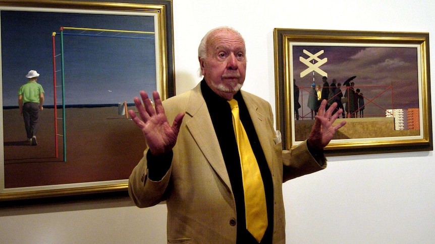 Jeffrey Smart with two of his artworks at the National Gallery in Canberra.