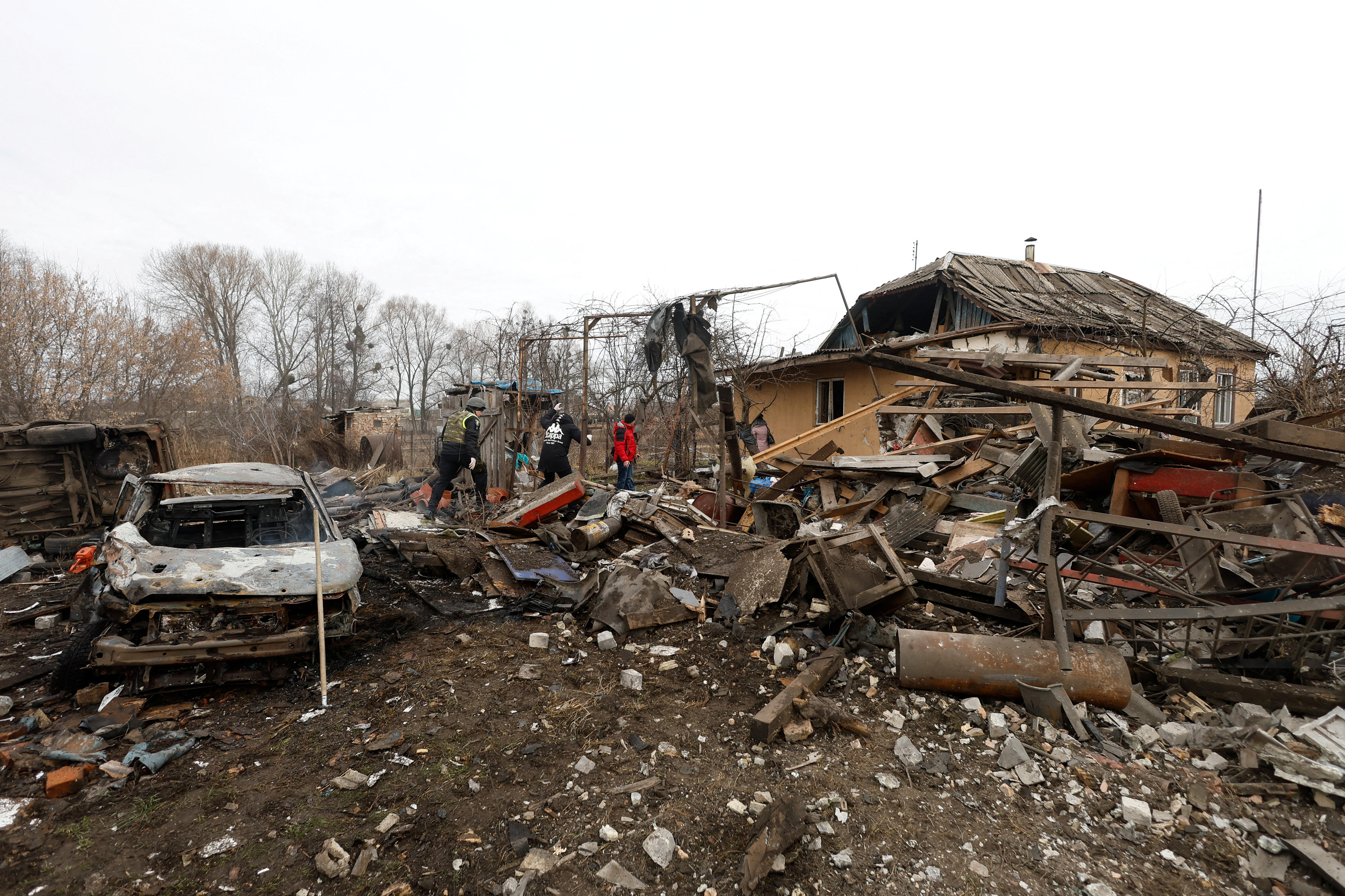 Authorities at the site of a residential home and car destroyed by a Russian air strike.