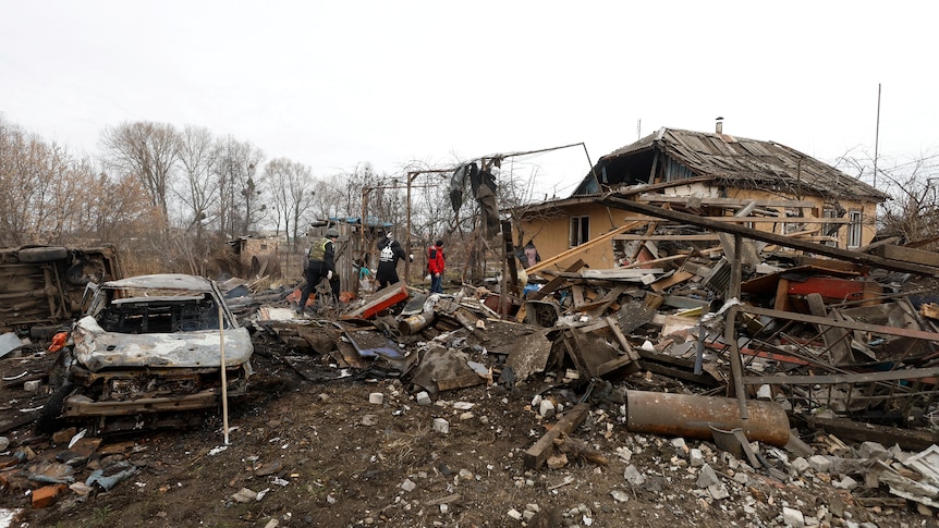 Authorities at the site of a residential home and car destroyed by a Russian air strike.