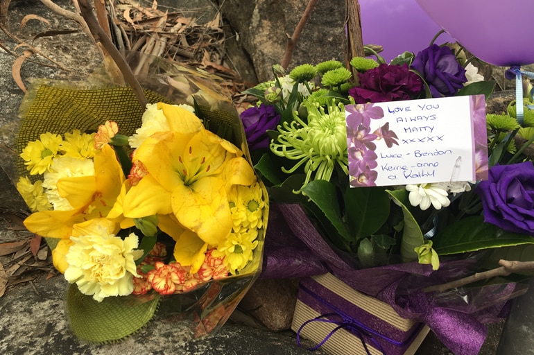 Picture of flowers laid by roadside near the crime scene where investigators are looking for Matthew Leveson's body