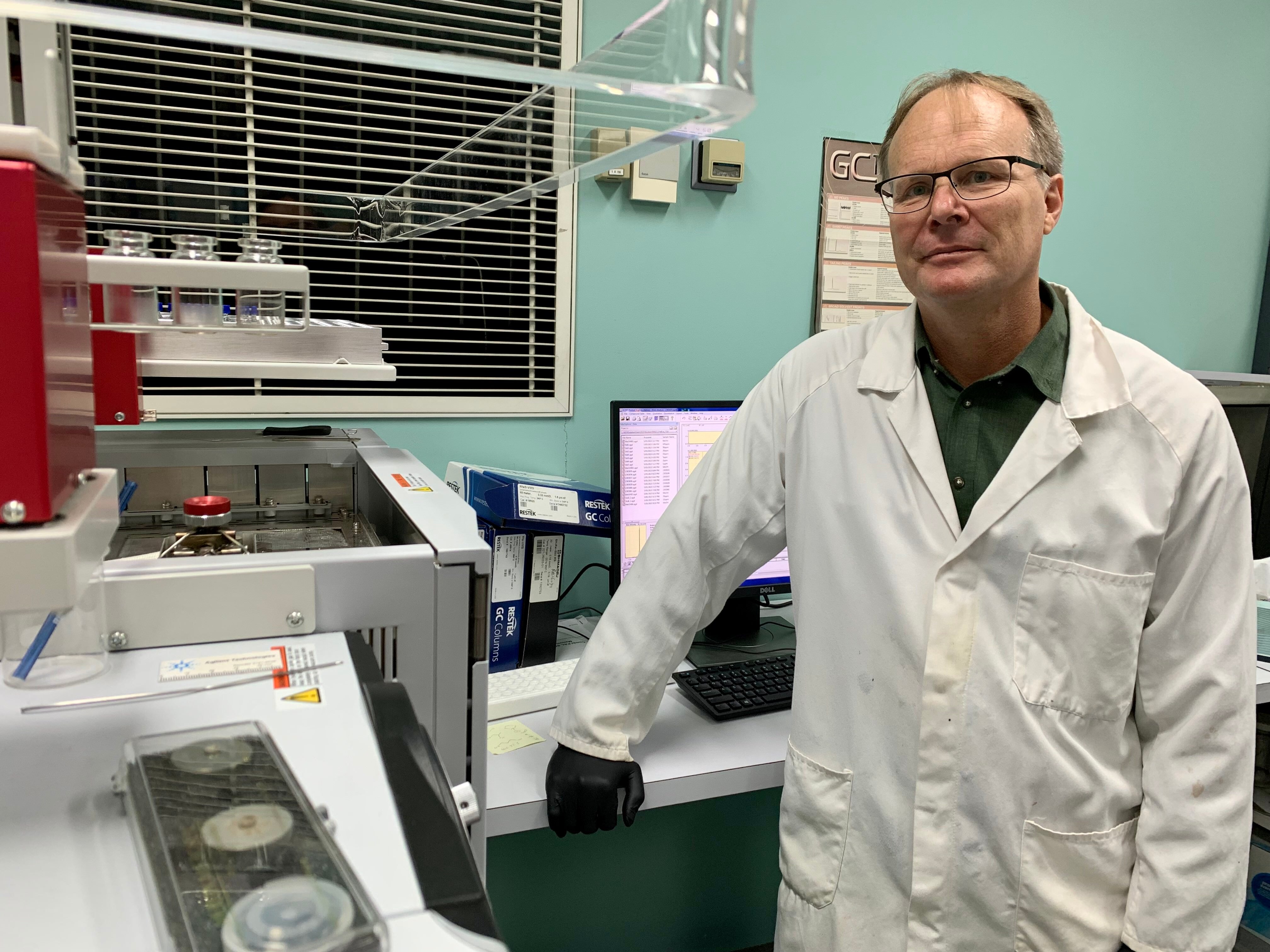 David Pass stands near technical equipment at Queensland Health's Forensic and Scientific Services lab