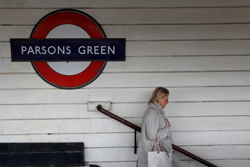A woman walks down a set of stairs near a sign saying "Parsons Green"