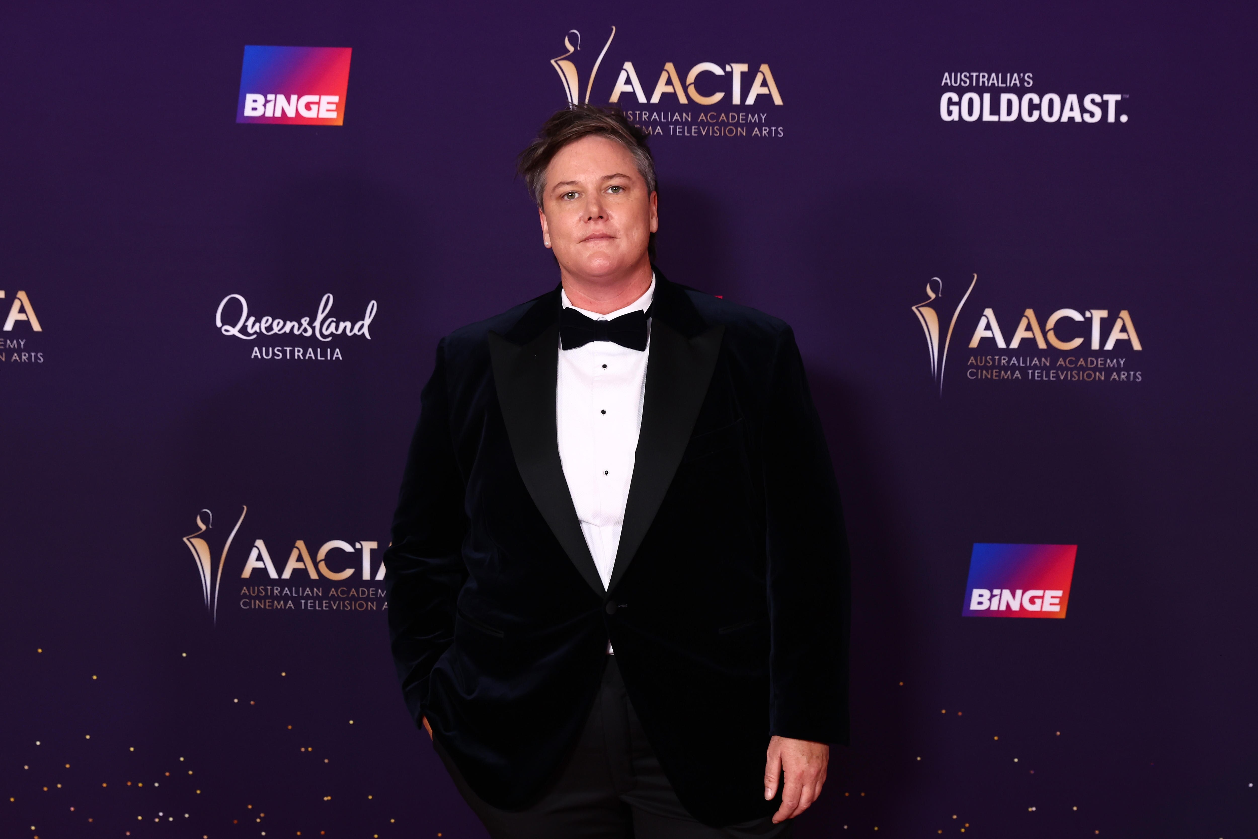 Hannah Gadsby wears a black suit with a bow tie