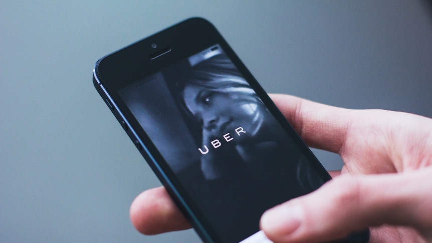 A woman uses the Uber app on her mobile phone.