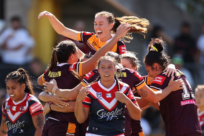 A group of NRLW players celebrate a try 