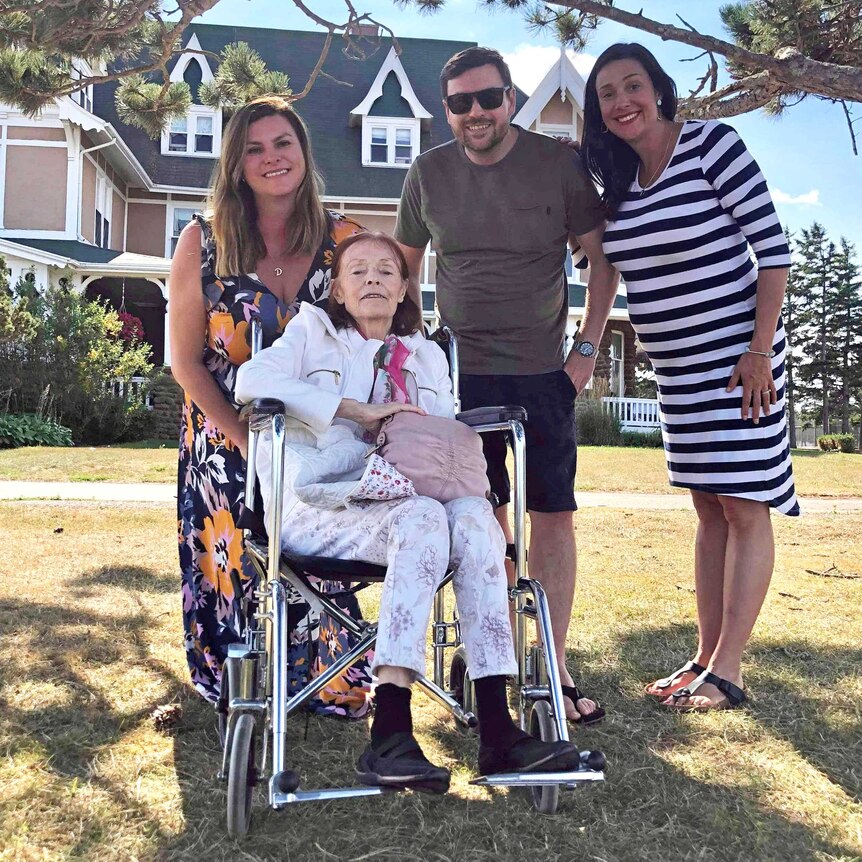 A family of two sisters and one brother with their mother, who is in a wheelchair.