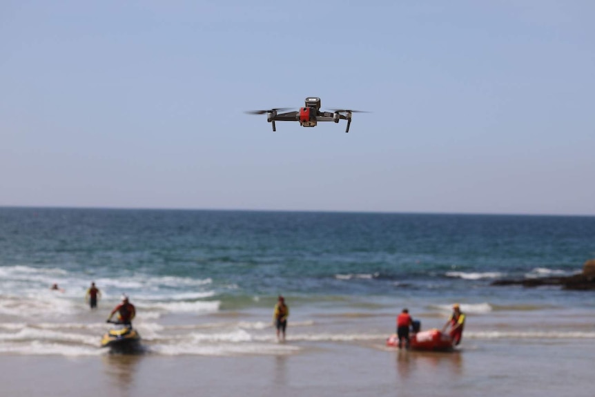 A drone flies over a beach