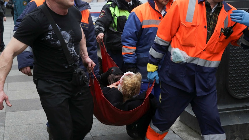 An injured person is helped by emergency services outside Sennaya Ploshchad metro station