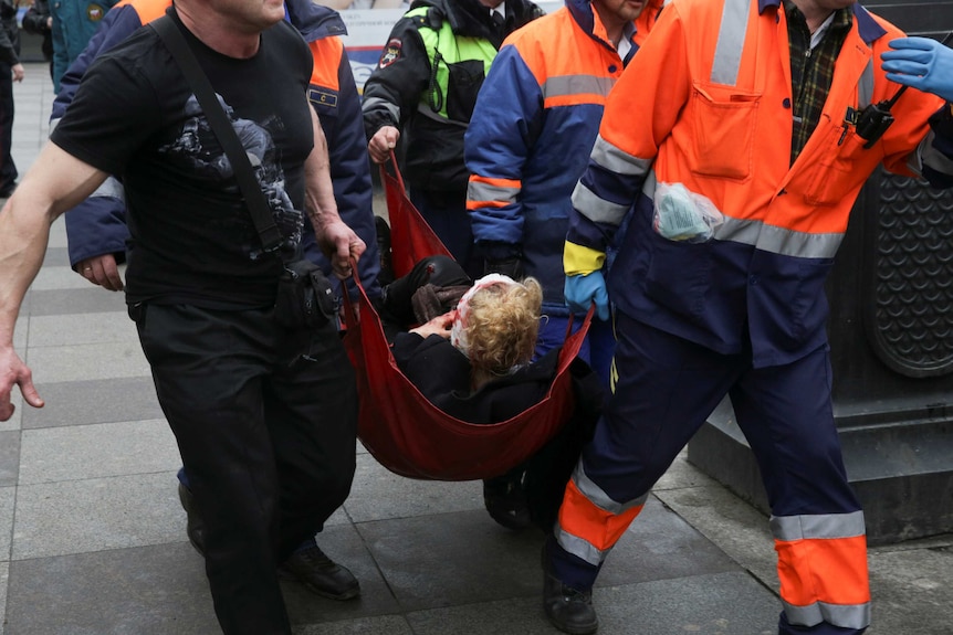 An injured person is helped by emergency services outside Sennaya Ploshchad metro station