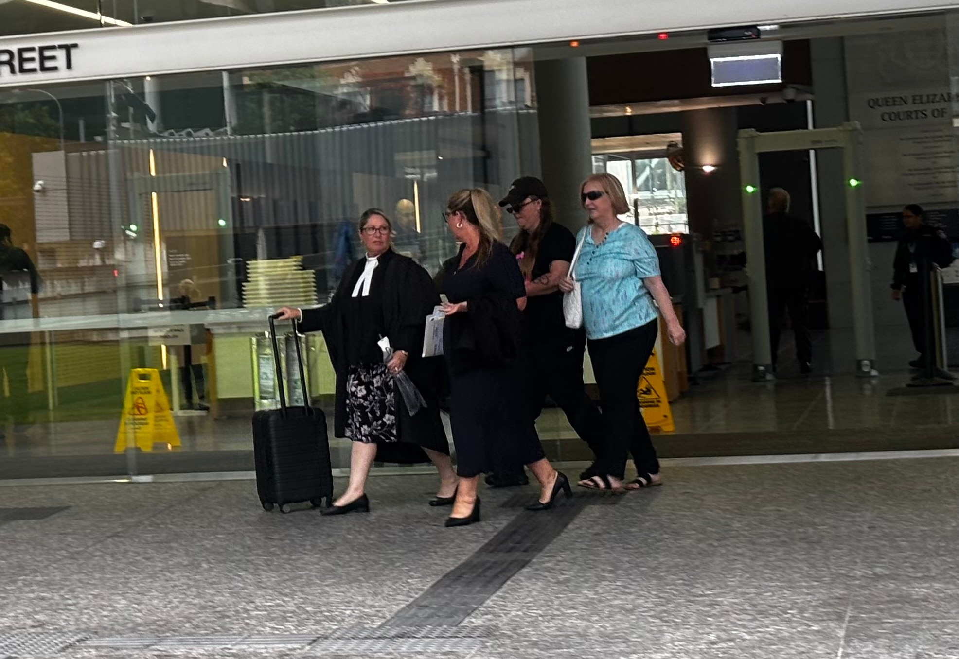 a group of people leave brisbane court house
