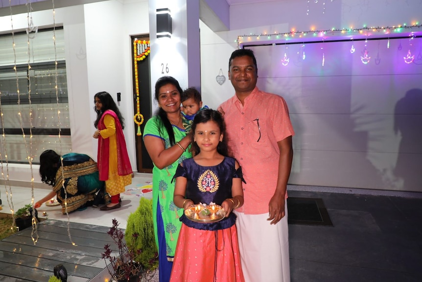 A family celebrating Diwali holding plates of food