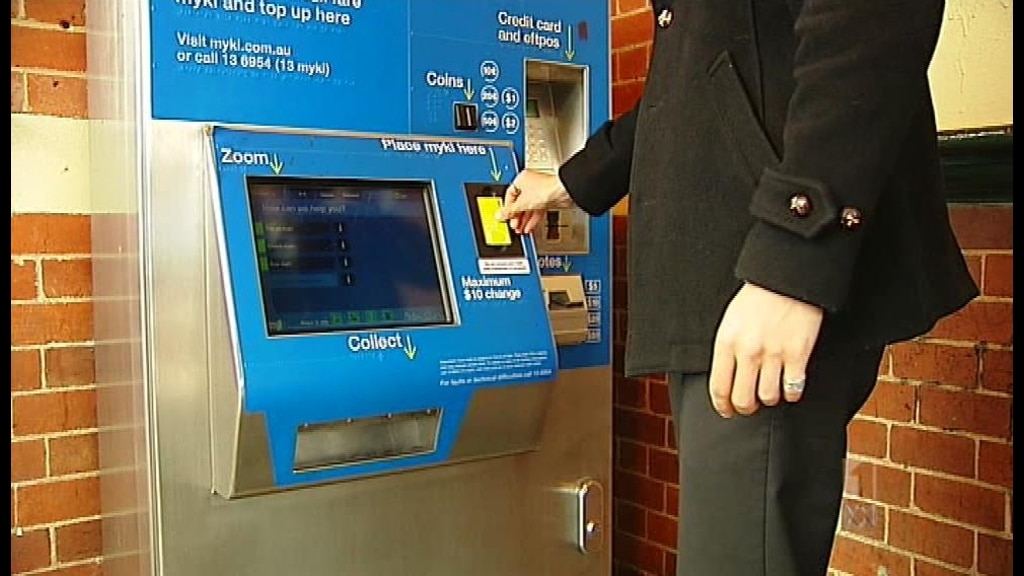 Man pays for a train fare at an old myki ticket machine.