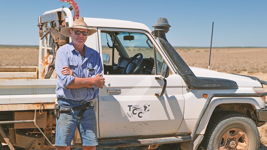 A man stands near his ute with his hands crossed