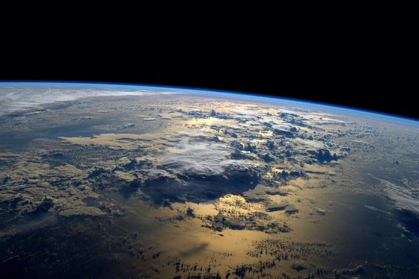 A small portion of Earth, seen from the International Space Station, showing the curve of our blue planet, oceans and clouds.