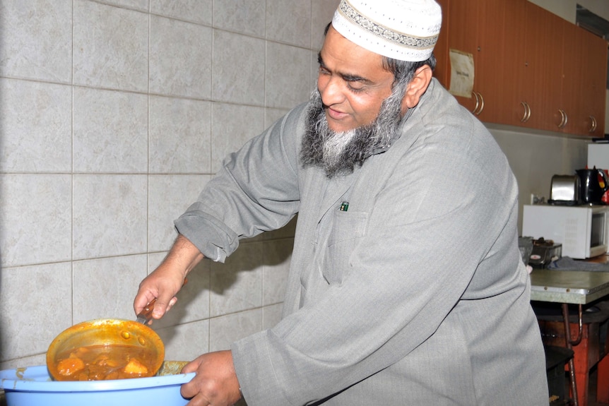 A man serves curry at the Darra Mosque during Ramadan on August 5, 2011.