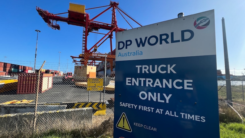 Shipping cranes in background, DP World sign saying truck entrance only