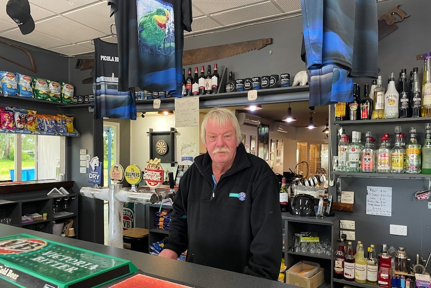 a man standing behind the bar in a pub