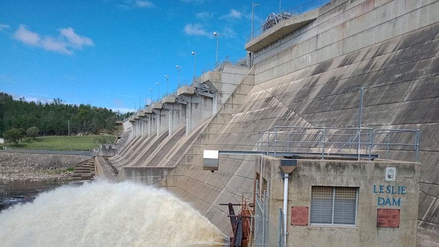 Water gushing from the base of the Leslie Dam wall into a creek.