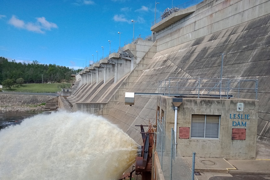 Water gushing from the base of the Leslie Dam wall into a creek.