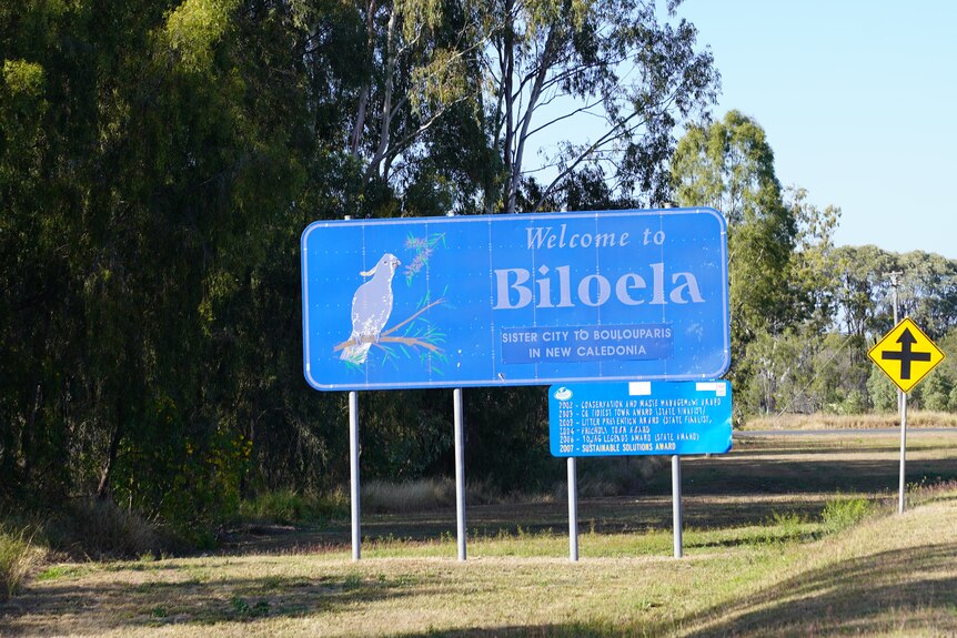 A blue sign with a cockatoo picture reads 'welcome to Biloela'