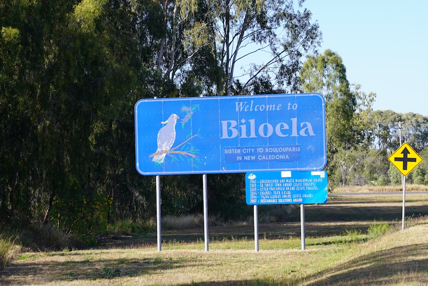 A blue sign with a cockatoo picture reads 'welcome to Biloela'