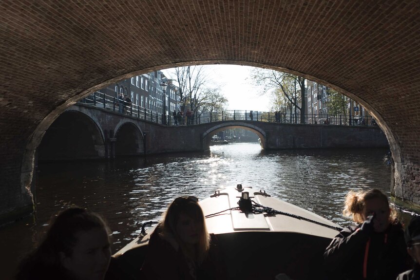 Passengers on a boat touring one of Amsterdam's famous canals.