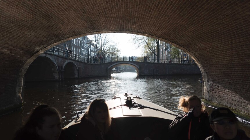 Passengers on a boat touring one of Amsterdam's famous canals.