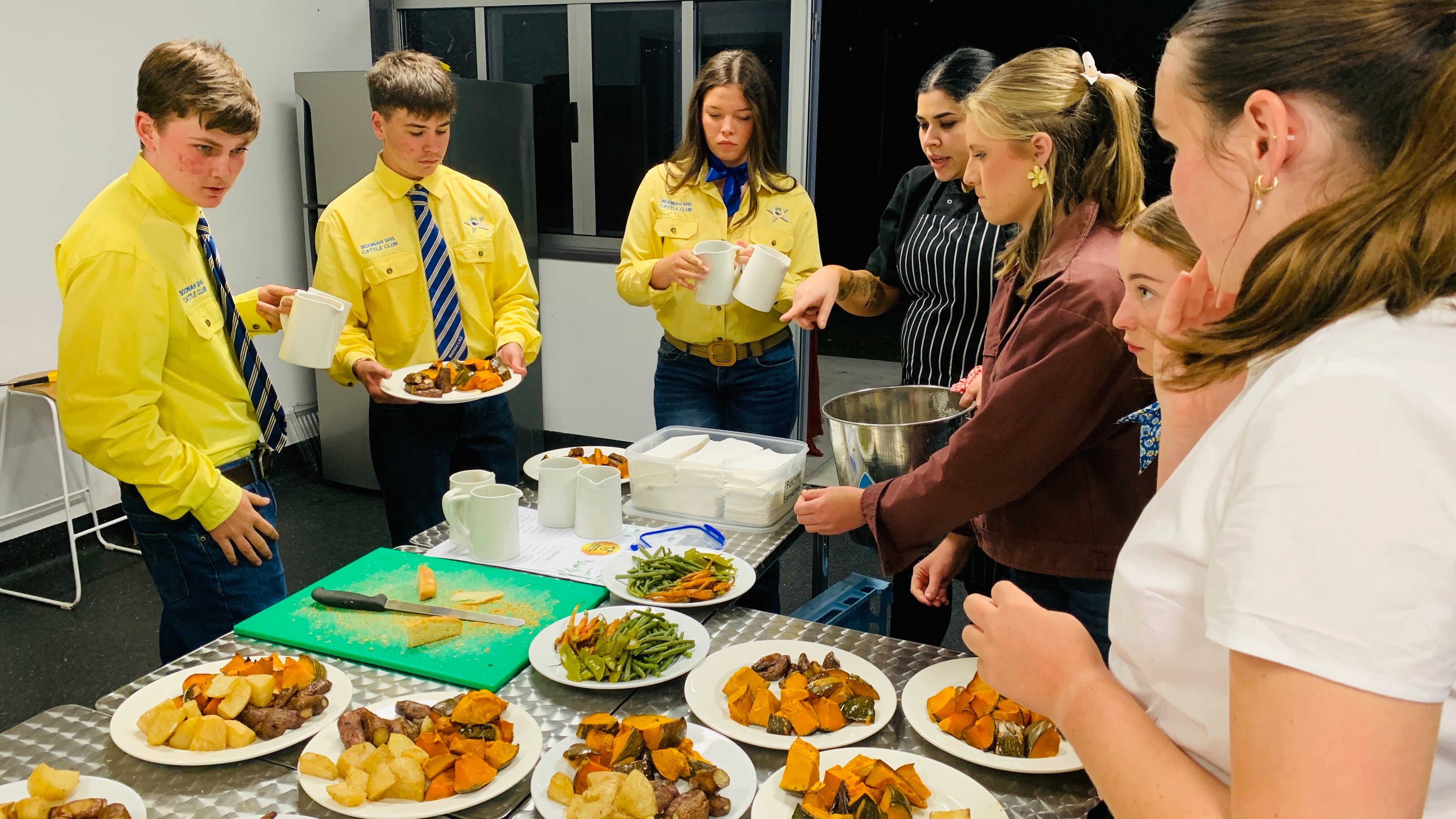 Los estudiantes de Boonah High preparan comidas para los invitados en la cocina.