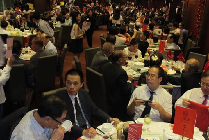 A large room filled with people eating, the ceiling decorated with red lanterns.