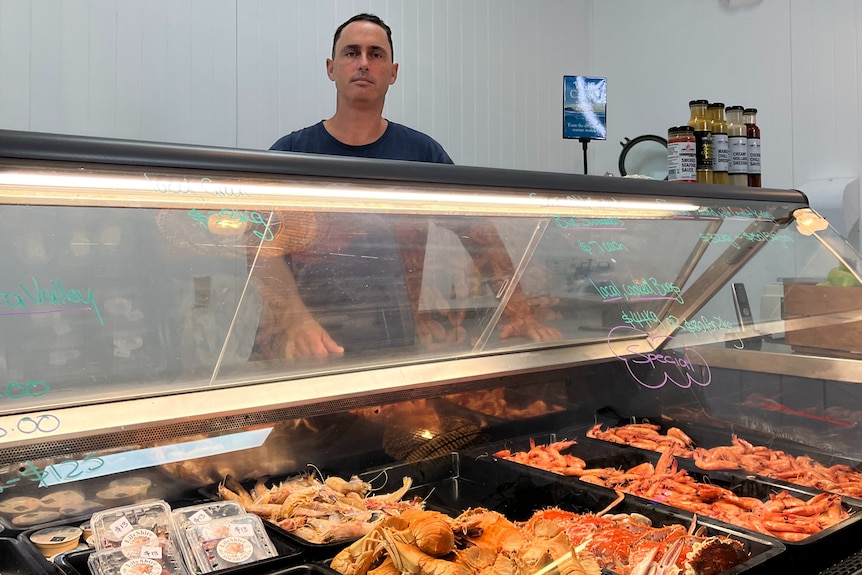 Lucas Danzie, seafood shop owner stands behind fresh seafood cabinet