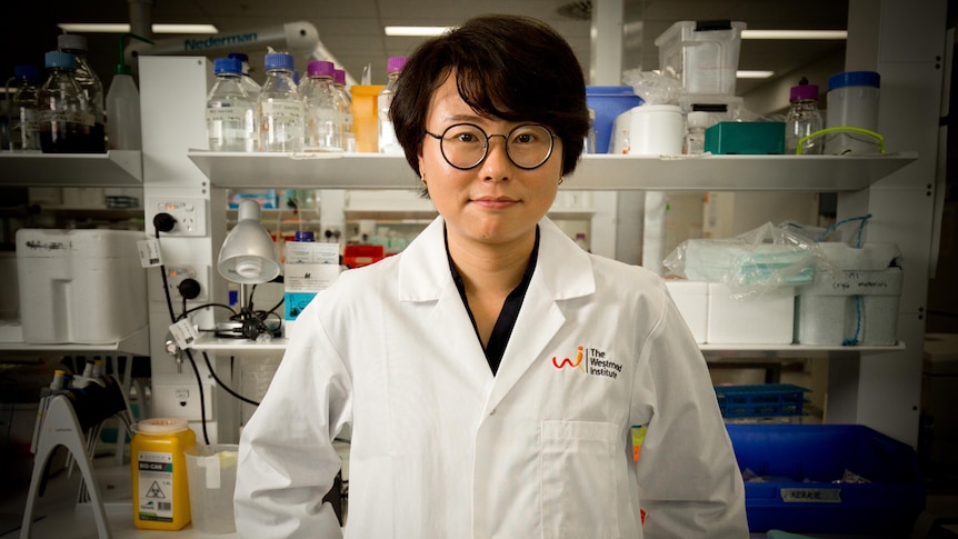 A young woman of asian decent wearing a lab coat.