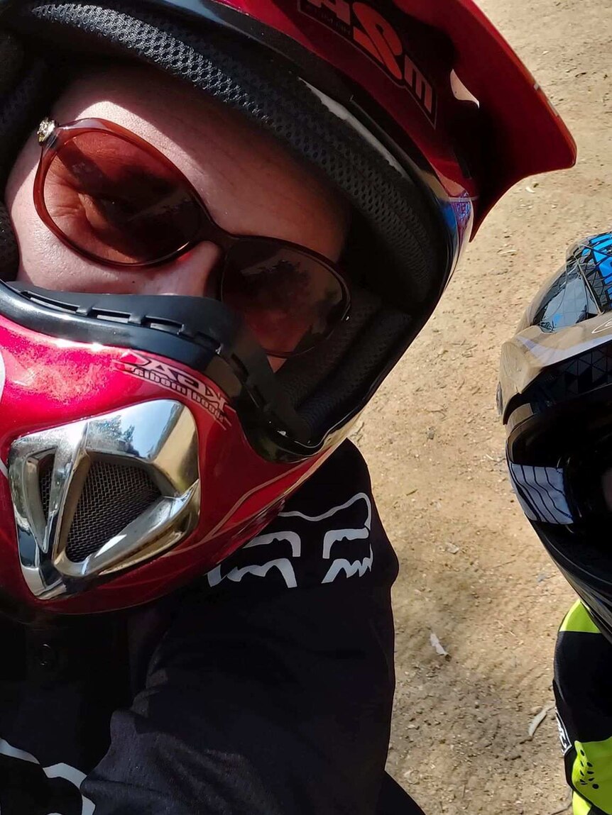 A woman and a boy wearing motorbike helmets. The woman wears sunglasses, the boy wears goggles.