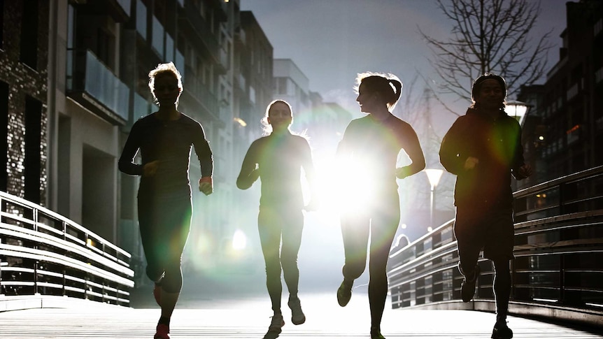 silouhettes of three women and one man running