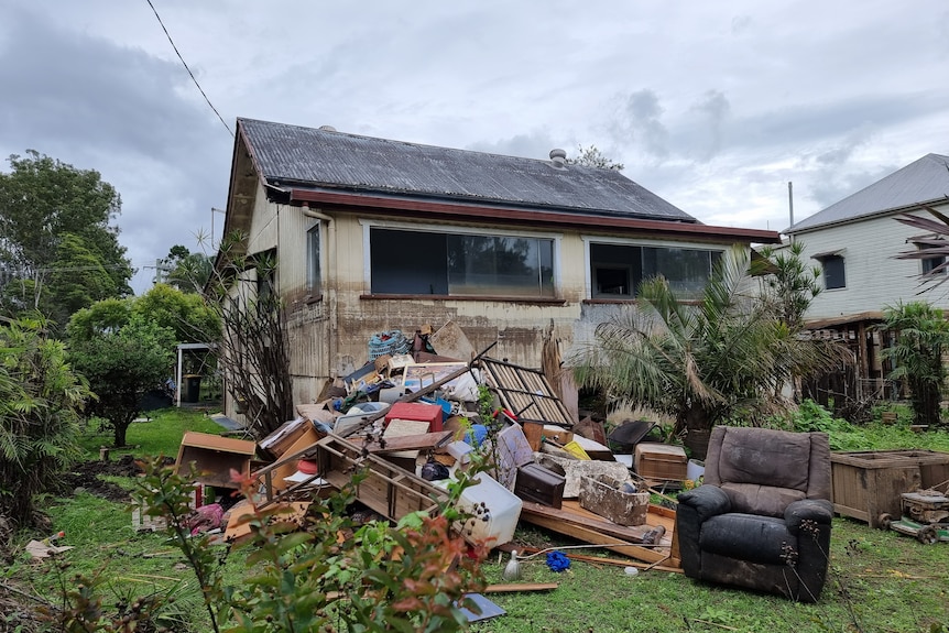 Thick black sludge remains on the walls of Dean Wilson's house at Bradwater, with all his furnature piled on his front lawn.