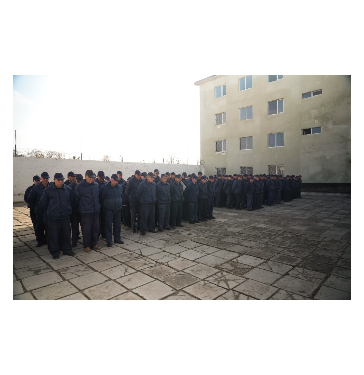 Russian prisoners of war stand at attention in the prison yard of a POW facility in Ukraine.