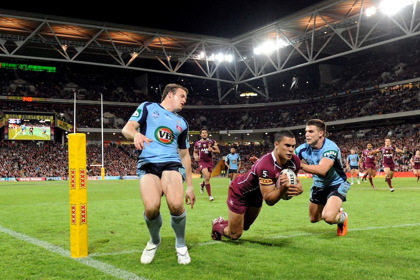 Jharal Yow Yeh dives over the tryline as two Blues defenders try to tackle him