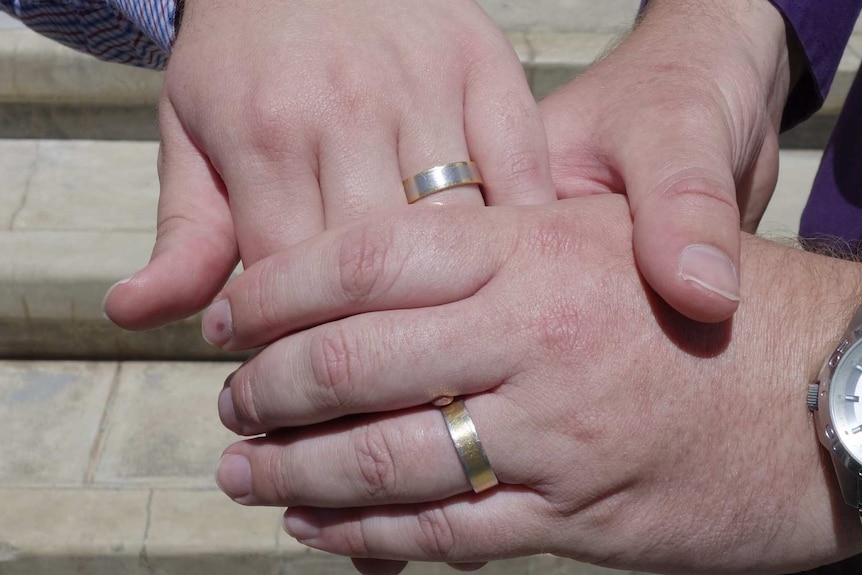 Ulises Garcia and Craig Berry show off their rings after being married in Canberra under the ACT's Marriage Equality Bill.