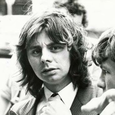 A black and white photo from 1979 of a young man with longish hair in a suit and tie, looking perplexed.