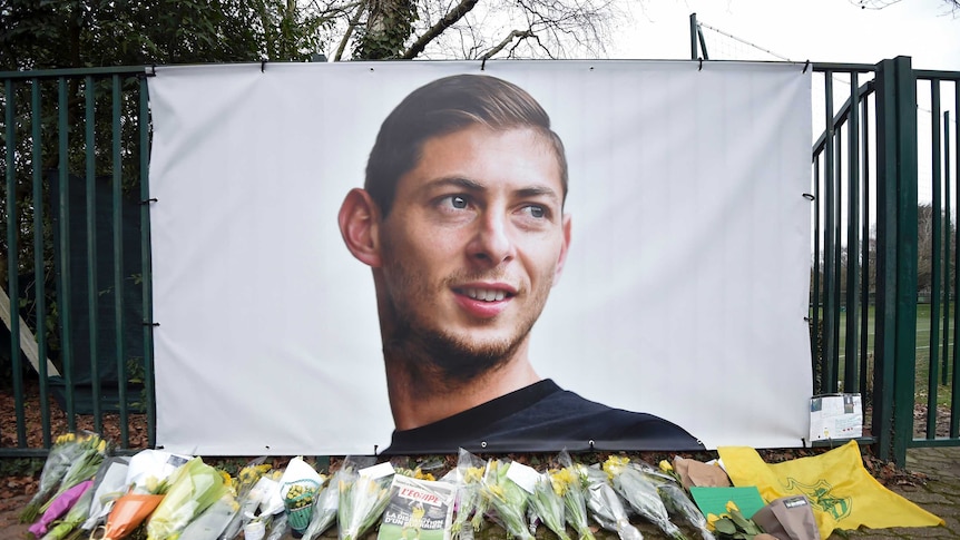 A memorial of Emiliano Sala with flowers in front of it after his flight disappeared