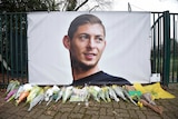 A memorial of Emiliano Sala with flowers in front of it after his flight disappeared