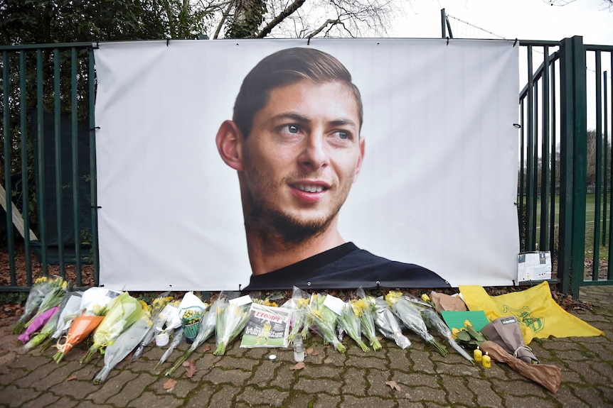 A memorial of Emiliano Sala with flowers in front of it after his flight disappeared