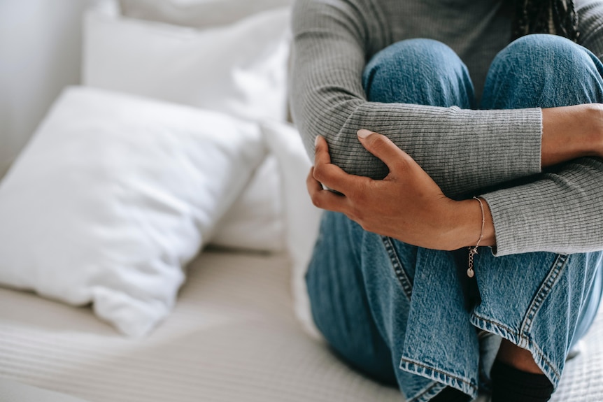 Woman in an anxious pose on bed