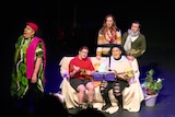 Five actors are performing a song on stage with ukuleles