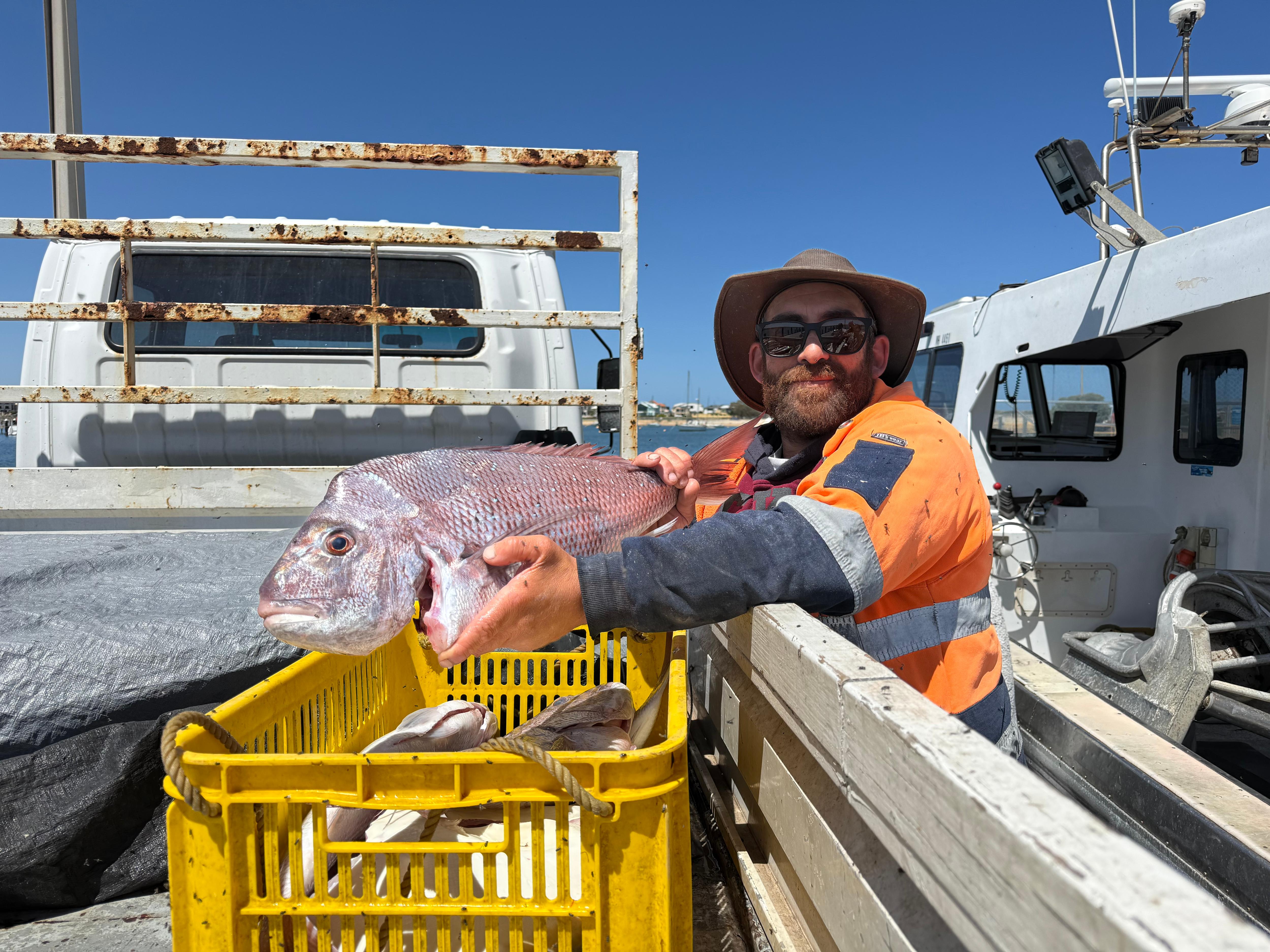 Metade de um homem segurando um peixe.