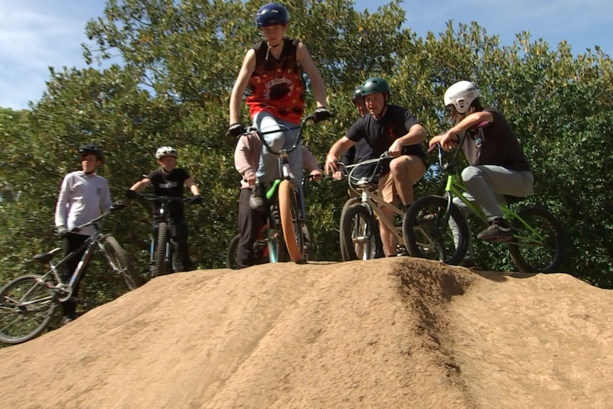 A group of boys on bikes on a hill