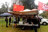 Soviet and Australian Communist Party flags flying above a marquee