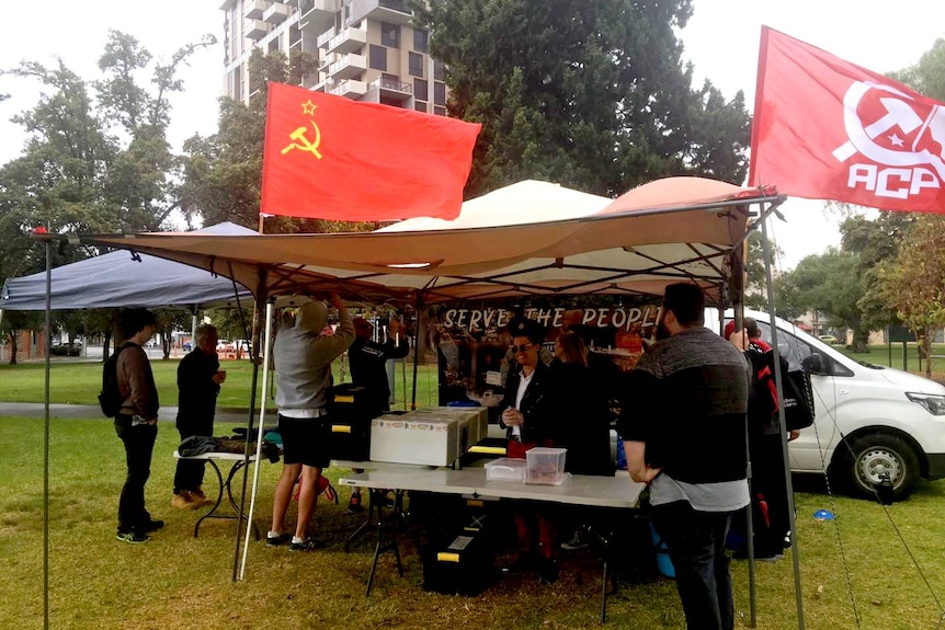 Soviet and Australian Communist Party flags flying above a marquee