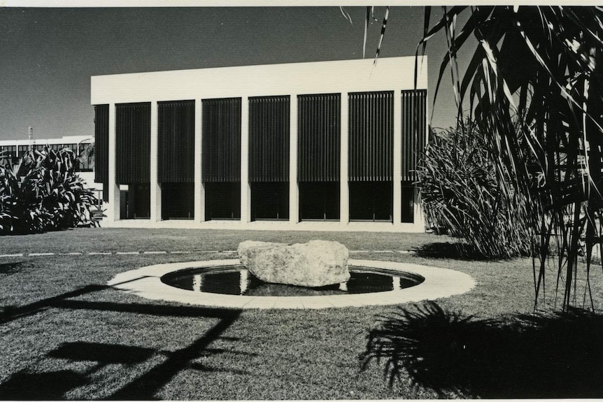 A big square building in darwin, in black and white.