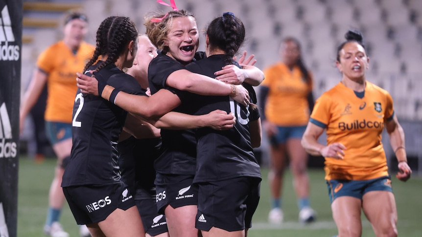 Black Ferns players embrace after scoring a try against the Wallaroos.